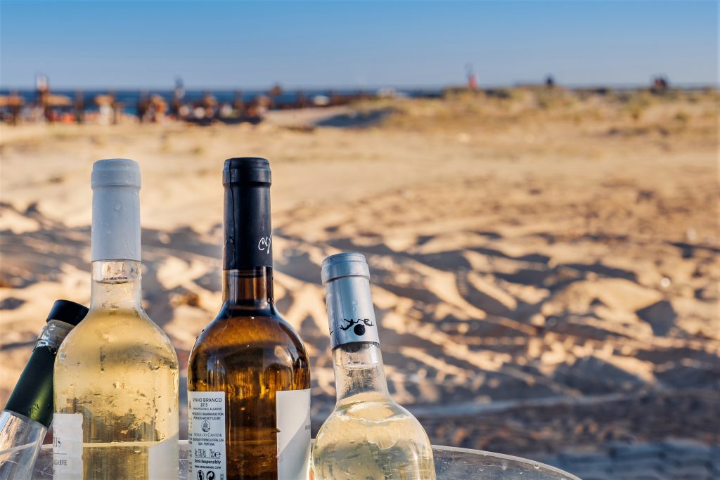Weißwein am Strand genießen kommt bei Algarve-Touristen gut an